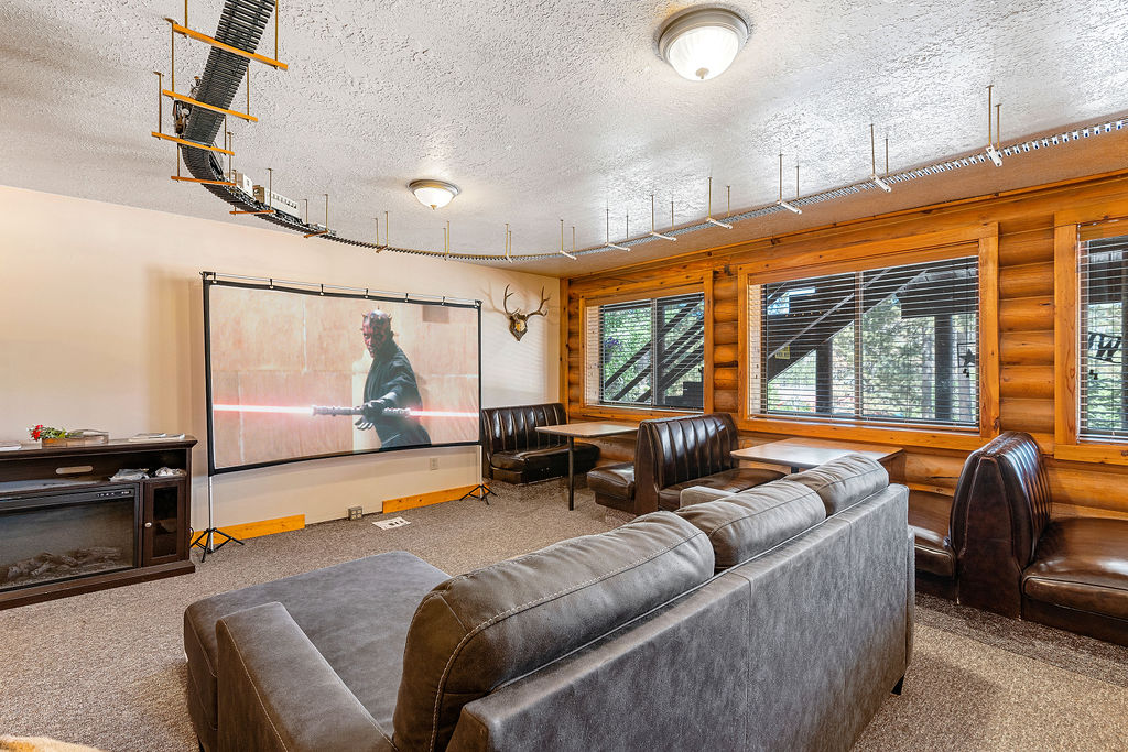 Shared recreation room with big screen TV, sectional sofa, and booth seating at Duck Creek Village Inn.