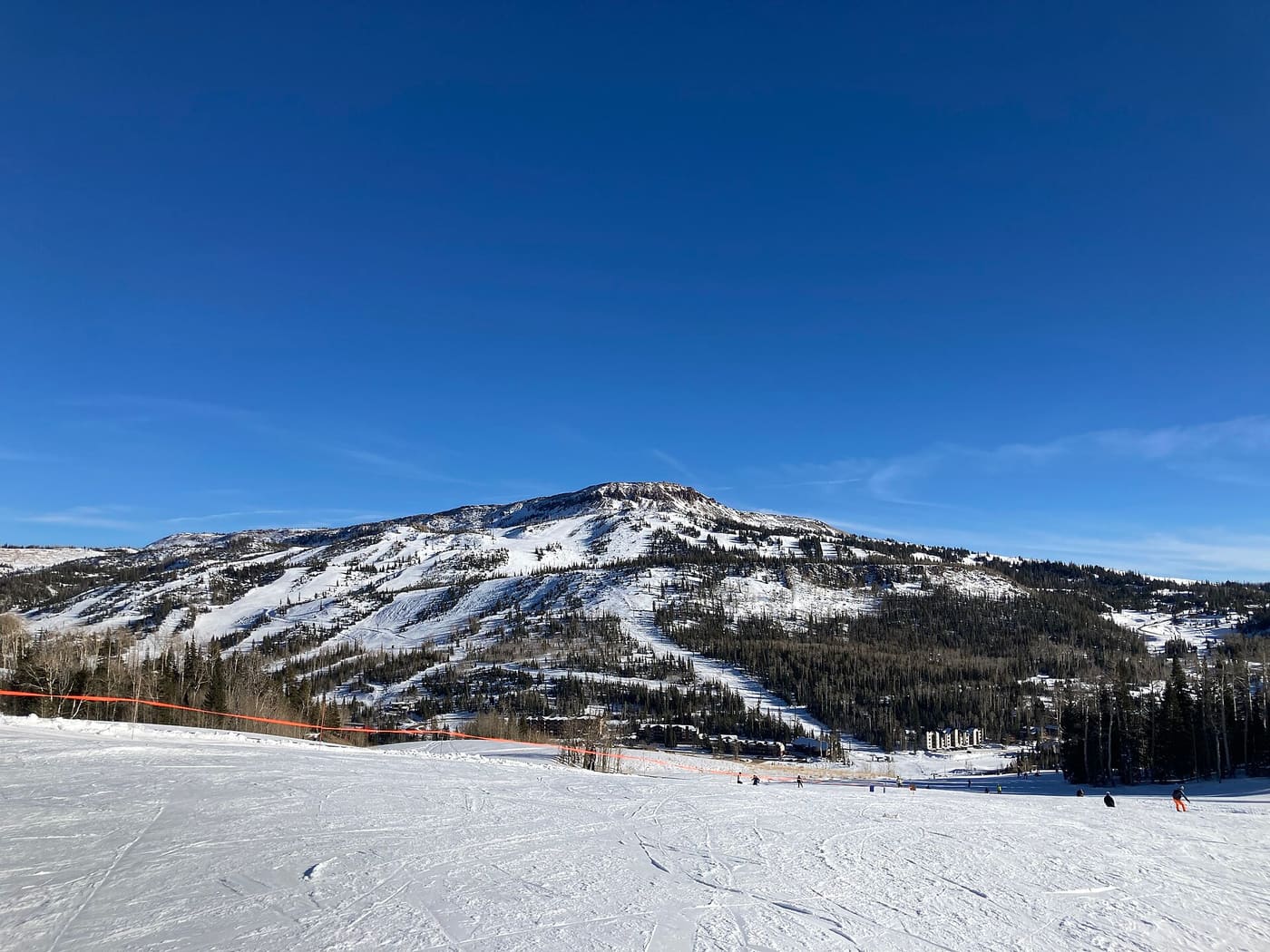 Brian Head Peak and the Giant Steps side of the resort seen across a groomed run on a clear December day