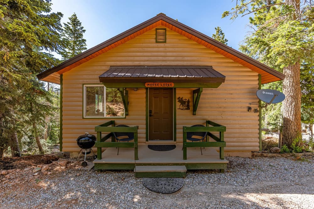 Außenansicht der Moose Cabin zwischen Kiefern in Duck Creek Village
