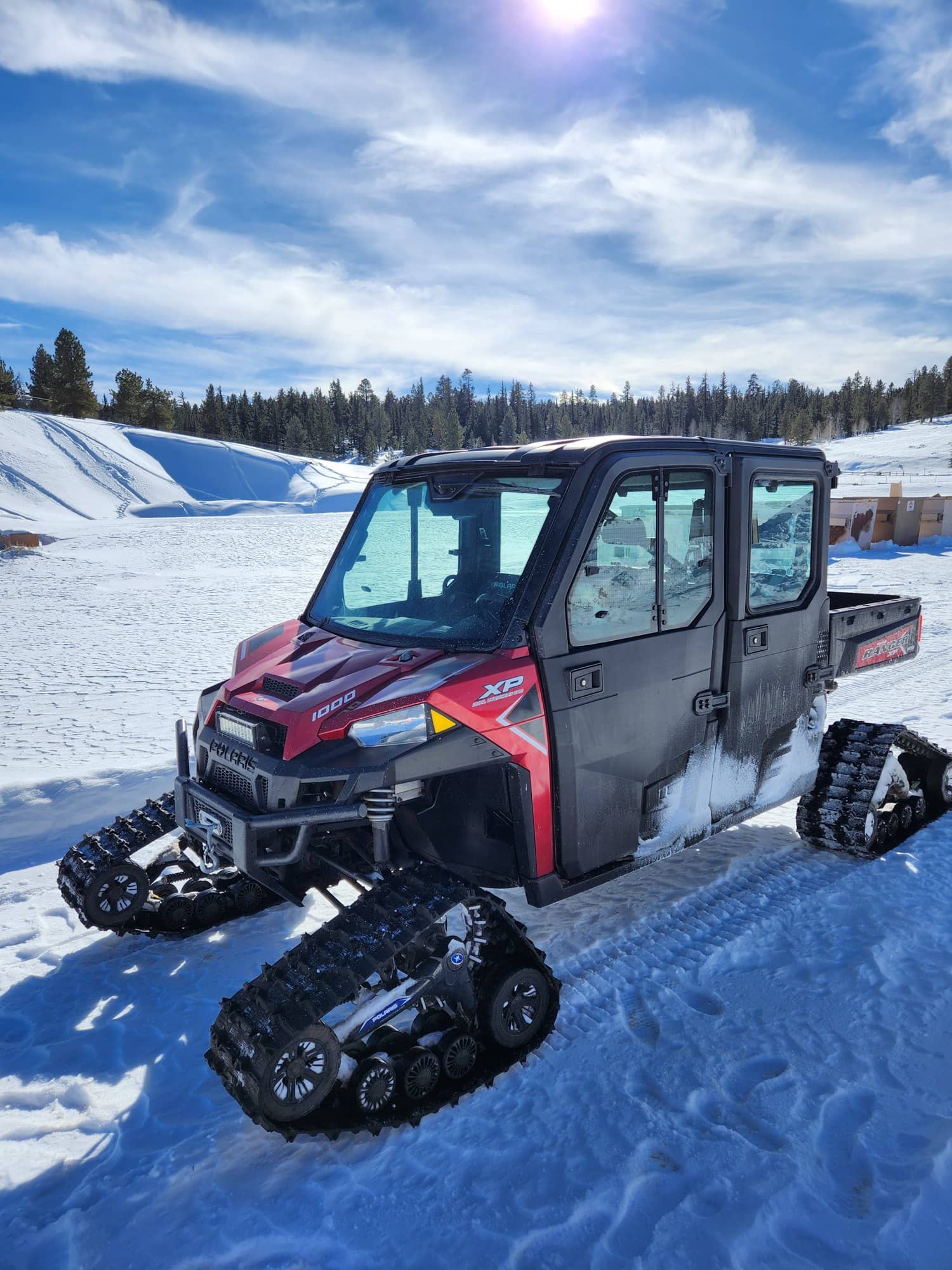 A tracked side-by-side parked on a snowy street in Duck Creek Village