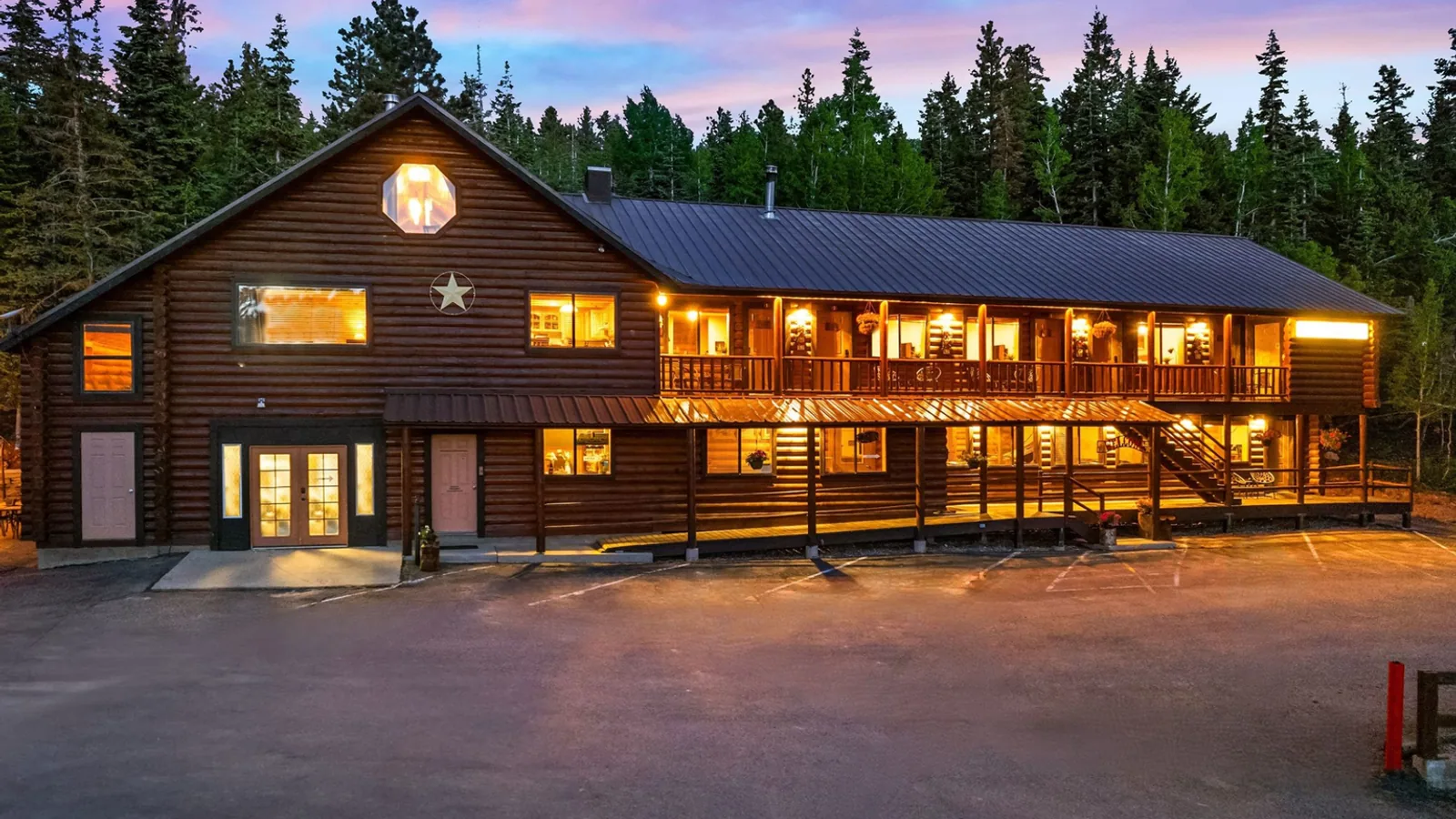 Duck Creek Village Inn lit up at dusk with its parking lot in the foreground, where the yard sale is held