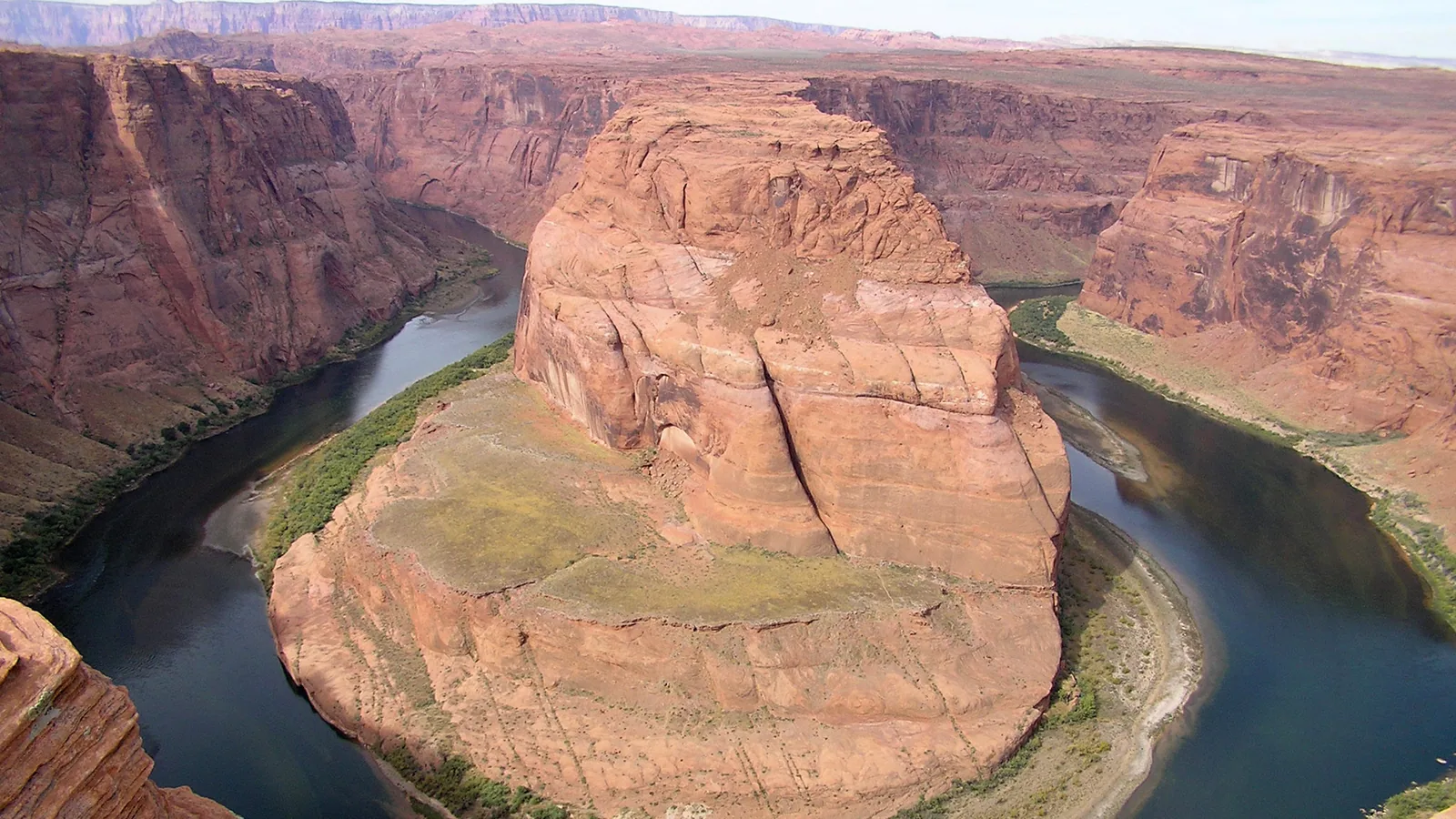 The Colorado River curving around a red sandstone butte at Horseshoe Bend, seen from the rim of Glen Canyon