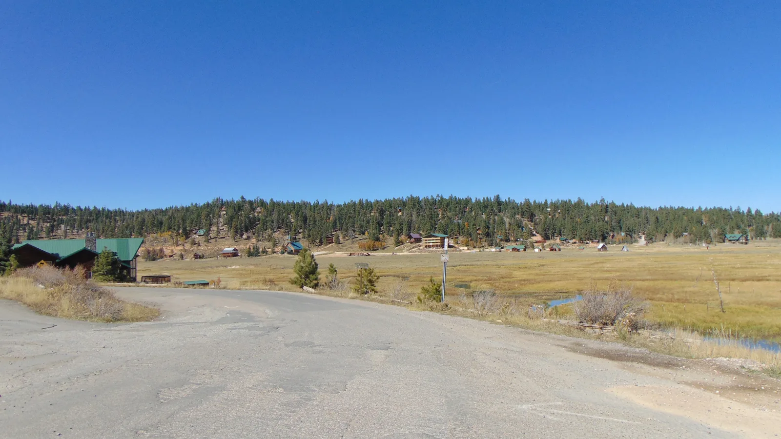 Cabañas dispersas entre pinos sobre un prado en el lado norte de Duck Creek Village, Utah
