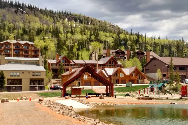 Bristlecone Pond with the resort lodge and village buildings behind it in summer