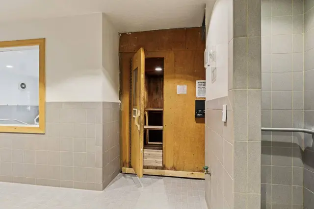 Wood-lined dry sauna door inside the community spa room