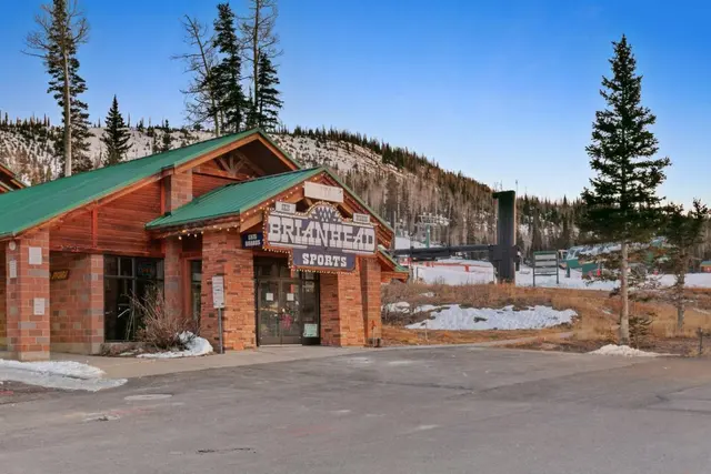 Log-sided Brian Head Sports ski rental shop on a winter afternoon